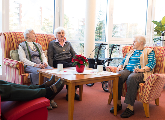Drei Bewohnerinnen unterhalten sich in einer gemütlichen Sitzecke im Seniorenzentrum